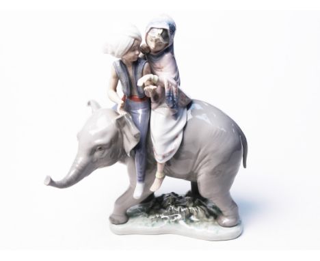 A Lladro figure of an Indian boy and girl riding an elephant. H23cm