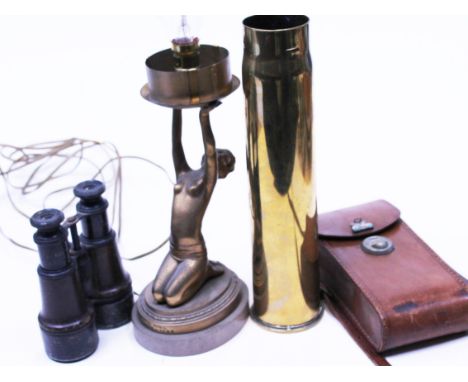  A mixed lot comprising an art deco lamp base, binoculars, a camera, a shell case and various linen 