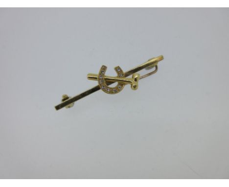 An 18ct gold and diamond farrier's brooch, the short bar holding in the centre a horseshoe set with ten single cut diamonds, 