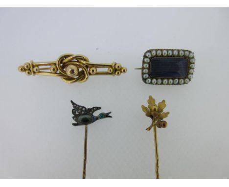 A Georgian lace pin, a flying duck stick pin, and two others, the lace pin rectangular with a vacant glazed panel in a border