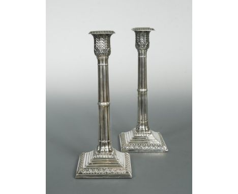 A pair of Victorian silver candlesticks, by Harrison Bros &amp; Howson, Sheffield 1890, the square stepped bases decorated wi