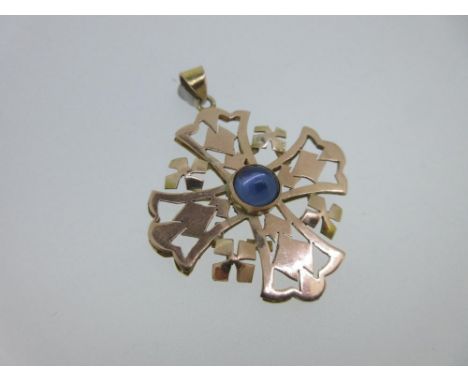 A pendant cross set with a cabochon blue hardstone, the pierced and geometrically patterned Maltese cross with quatrefoils be