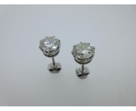 A pair of single stone diamond earstuds each weighing approximately one and a half carats, each round brilliant cut diamond e