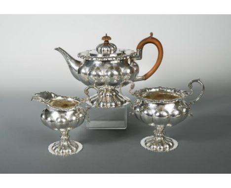 An Edward VII silver three piece tea set, by George Nathan and Ridley Hayes, Chester 1907, with hammered finish, the teapot o