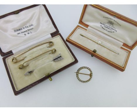 A diamond and onyx jabot pin designed as an arrow together with four other brooches or pins, the arrow point and flight set w