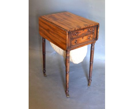 A Regency Mahogany Work Table, the drop flap top above two frieze drawers opposed by dummy drawers and with fabric wool bag r