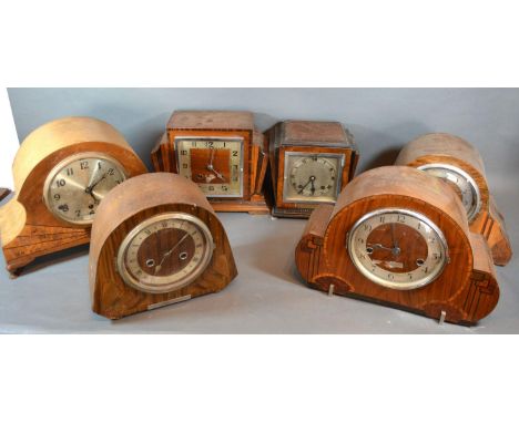 A Walnut and Ebonised Art Deco Mantle Clock with silvered dial together with another similar Art Deco mantle clock and four o