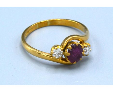 An 18ct. Gold Ruby and Diamond Crossover Ring with a central oval ruby flanked by diamonds, 4.1 gms. all in, ring size U 