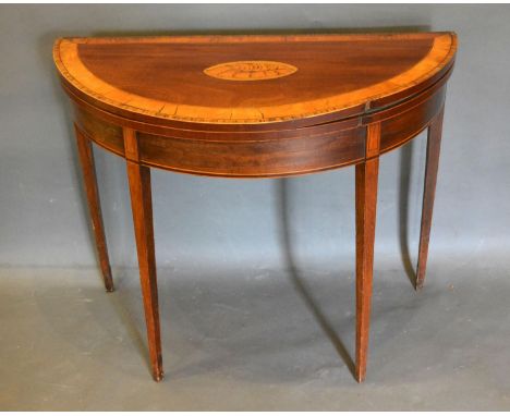 A George III Mahogany and Satinwood Inlaid Demi-Lune Card Table, the shell crossbanded inlaid top above a baise lined interio