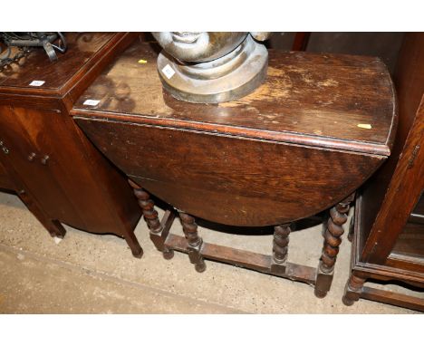 An oak barleytwist gate leg dining table and a set of three rail back chairs 