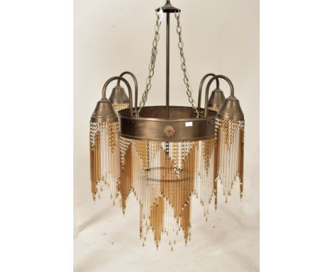 An Art Deco inspired 20th century bronzed metal &amp; glass rod four arm ceiling chandelier light. The chandelier having a ce