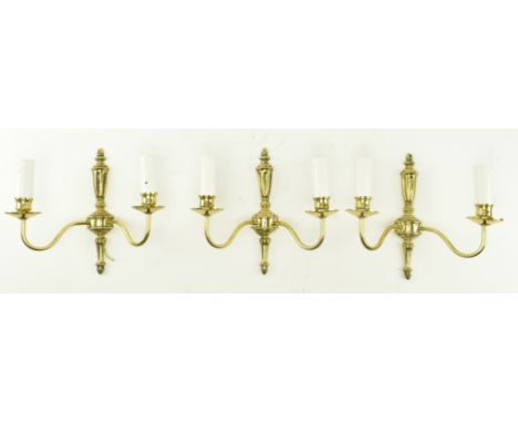 A set of three Italian manner 20th century gilded metal twin arm wall sconces. Each light having a turned wall mount over twi