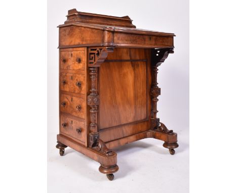 A 19th century Victorian walnut Davenport desk. The desk with carved columns to the front having a bank of drawers to the rig