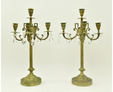 A pair of French inspired early 20th century brass desk table candelabras. Each candlestick having a turned finial atop over 