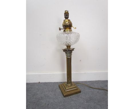 A Victorian oil lamp converted to electricity with crystal glass reservoir, column stem to stepped base 