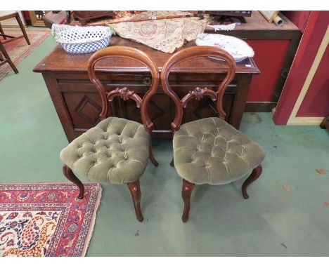 A circa 1840 pair of spoon back chairs with carved decoration over a button serpentine front seat of cabriole legs