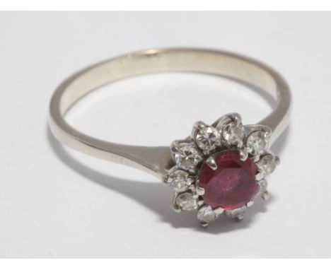 Ruby and diamond circular cluster ring, on unmarked white metal shank, tests as gold, ring size O