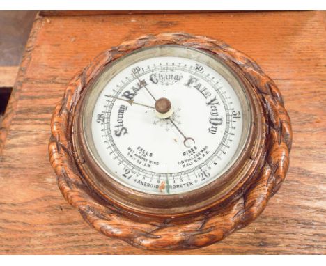 Circular wall barometer in carved oak case