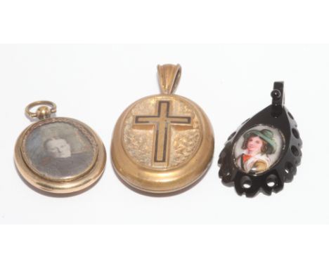 Two oval pinchbeck pendants, one with enamel cross and the other with memorial inscription, and a jet pendant with hand paint