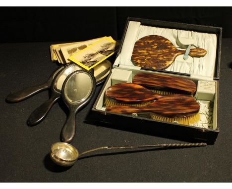 A set of three ebony dressing table mirrors; a faux tortoiseshell dressing table set, cased; an unmarked white metal ladle in