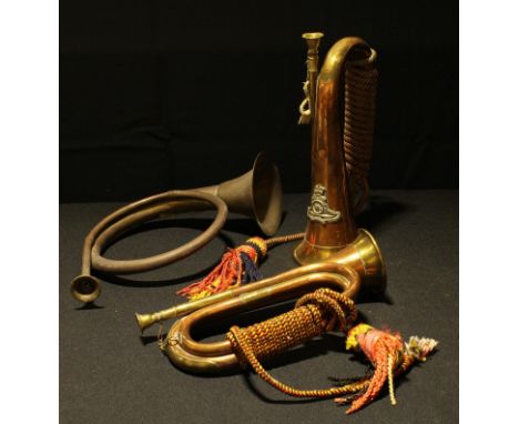 A military style copper bugle with brass badge, tasselled; another similar; a copper horn (3) 