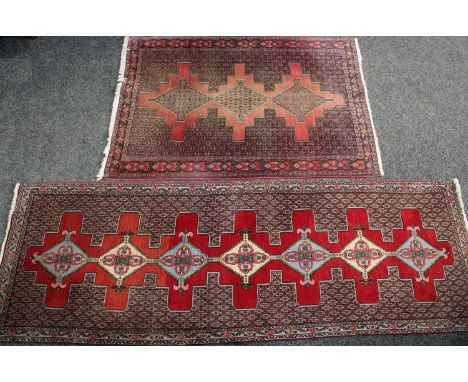 A rectangular Middle Eastern carpet, stylised flowers and geometric motifs, 280cm long, 94cm wide; another, 174cm long, 123cm