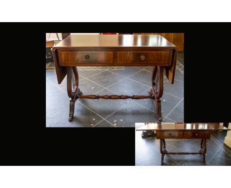 A Mahogany Sofa Table Of typical form with lyre shaped supports, turned cross stretcher, terminating in brass capped claw fee