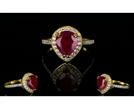 Ruby and Natural White Zircon Ring, a pear cut ruby of 4.25cts framed with .75cts of round cut white zircon set in a 14ct gol