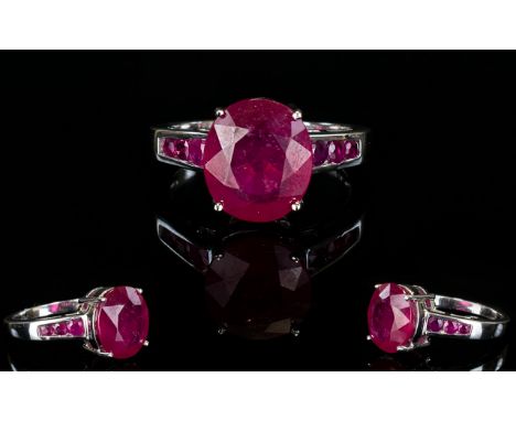 Ruby Raised Solitaire Ring, an 8.5ct oval cut ruby raised above the shank, where the shoulders are each set with a further th