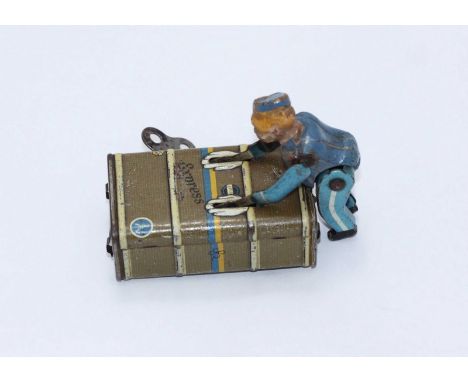 A Gescha lithographed clockwork tinplate hotel porter pushing a cabin trunk