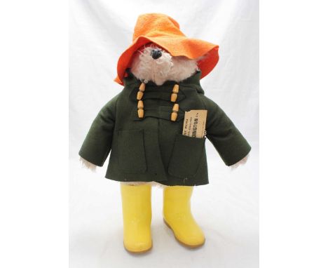 A 1974 Paddington Bear stuffed toy, design 957892, in green duffel coat, orange felt hat and Dunlop Wellington boots with 'Pl