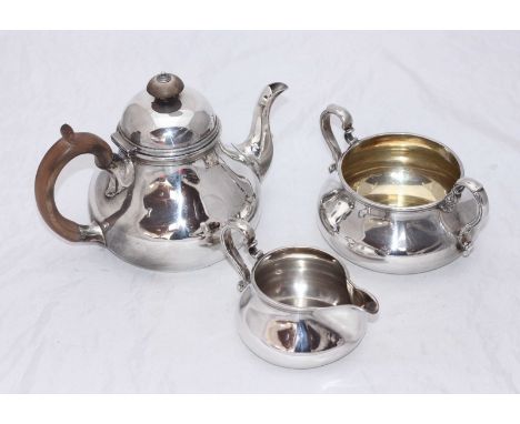 A late Victorian three-piece silver tea set by R.&S. Garrard & Co, of plain Augsburg form with fruitwood finial and scrolled 