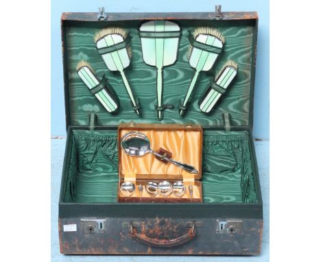 A 1930's green leather and green satin-lined travel case with five-piece silver and two-tone guilloche enamel-back brush and 