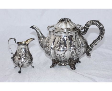 A Victorian silver teapot, of compressed globular form with foliate embossed panelled sides, scrolled handle and hinged cover