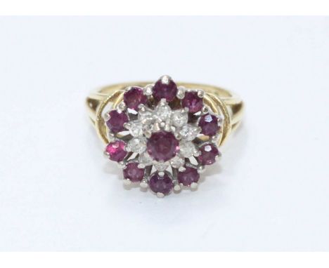 An 18ct gold dress ring set with diamonds and ruby coloured stones. Gross weight approximately 5.6g.