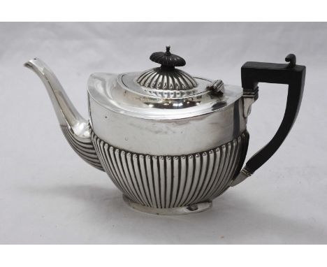A silver teapot, the body with a half reeded design and with a stained wooden handle and shaped finial. Hallmarked Birmingham