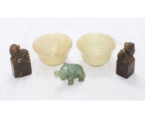 A pair of pale celedon jade drinking bowls, 10cm diam,(one repaired), together with a jade elephant and a pair of carved soap