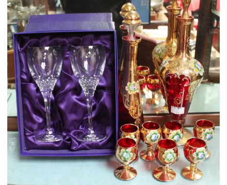 A Venetian ruby and gilt-glass liqueur set with  raised polychrome floral decoration, comprising two decanters and seven glas