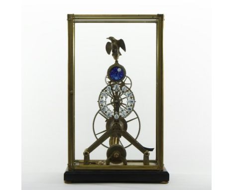A brass skeleton clock, surmounted by an eagle, with enamel moon phase above enamel hours showing Roman numerals, housed in a