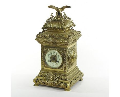 An ornate 19th century continental brass cased mantel clock, surmounted by an eagle, the enamel chapter ring showing Arabic n
