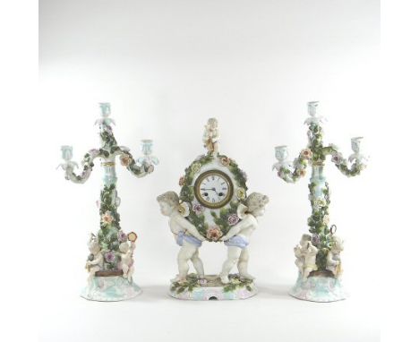 An early 20th century Sitzendorf porcelain three piece clock garniture, painted and encrusted with coloured flowers, with che