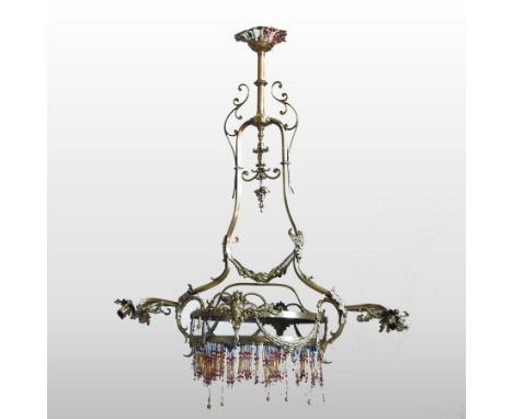 An early 20th century brass ceiling light, with ornate scrolled decoration, flanked by twin sconces, 100cm high overall
