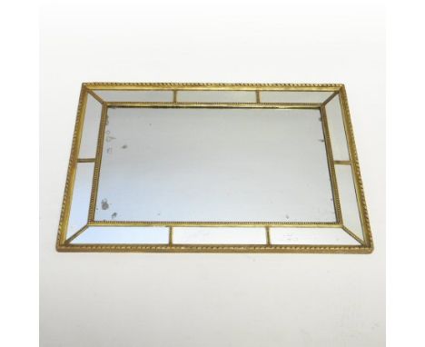 A Regency carved pine and gilt gesso framed wall mirror, having a rectangular plate, within a marginal surround, 64 x 97cm