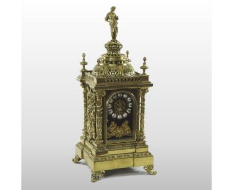 An ornate 19th century French brass cased mantel clock, surmounted by a figure, the enamel dial with Roman hours, signed A Ru