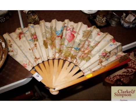 A large fan with boxwood sticks, the printed fabric panel decorated figures in a garden