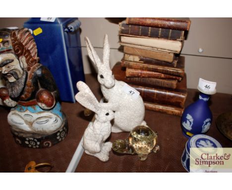 Two glazed pottery figures of hares; and a glass bubble decorated tortoise