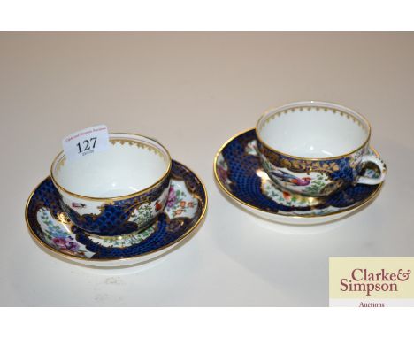 A pair of Worcester pattern cups and saucers, decorated exotic pheasants and flowers on a blue scale ground 