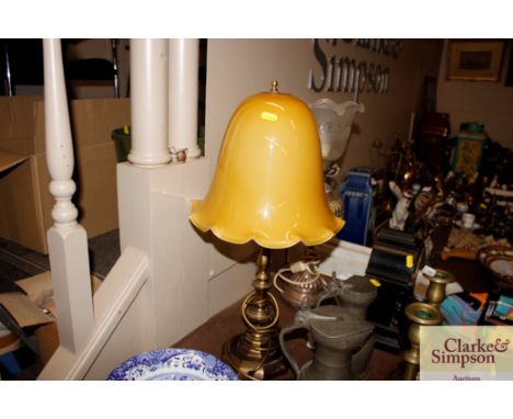 A brass table lamp with yellow glass opaque shade 