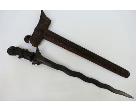 An Indonesian Kris with intricately carved scabbard and hilt, wave form blade (43 cm length)

Note: This lot is not for sale 