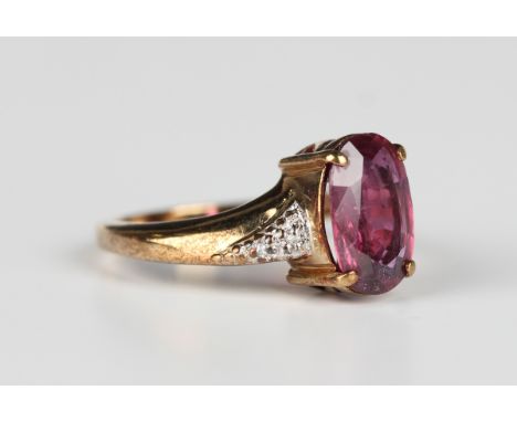 A 9ct gold ring, claw set with an oval cut ruby between diamond two stone shoulders, Birmingham 2007, weight 3.5g, ring size 